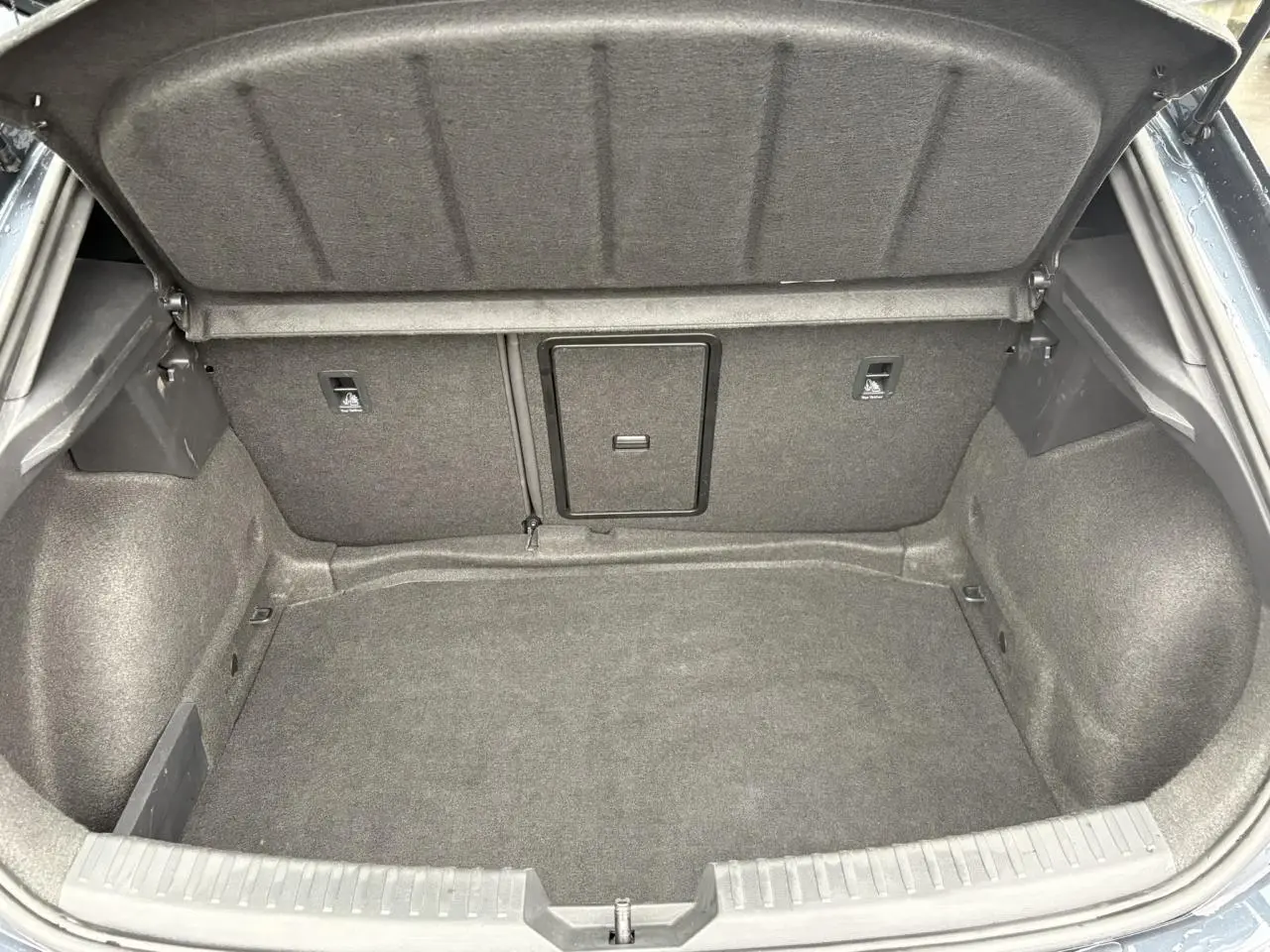 Coffre ouvert du SEAT LEON 1.5 e-TSI 150 DSG7 FR 2024 en Gris Magnétique, montrant un espace de chargement vide et propre.