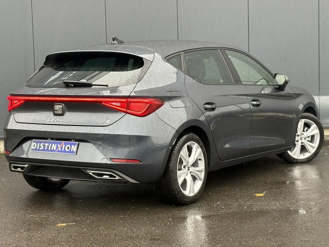Vue 3/4 arrière droite d'une SEAT Leon 1.5 e-TSI 150 DSG7 FR gris magnétique avec feux arrière LED et jantes alliage 17 pouces.