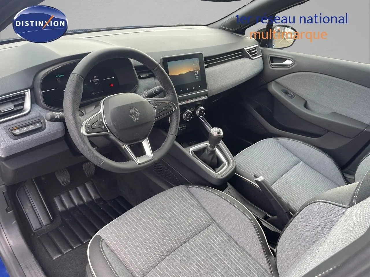 Vue intérieure côté conducteur de la Renault Clio TCe 90ch Techno 2025, avec tableau de bord moderne et sièges gris.