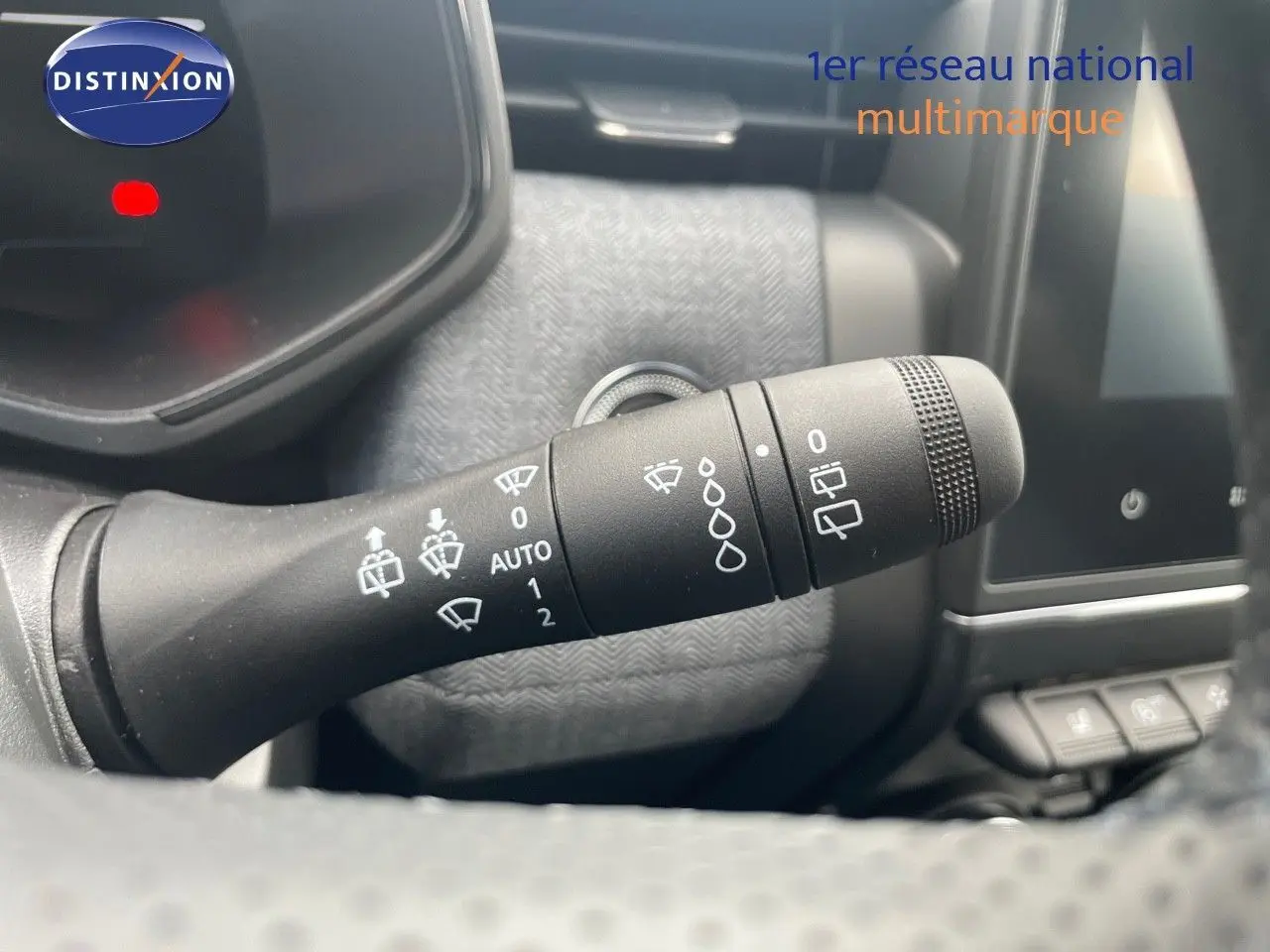 Gros plan sur la commande des essuie-glaces dans l’habitacle d’une Renault Clio bleu iron metal 2025.