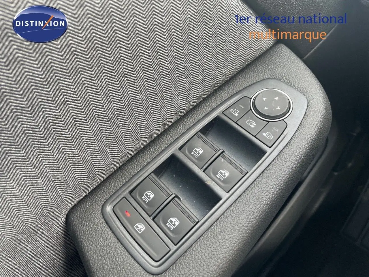 Gros plan sur les commandes des vitres électriques et rétroviseurs côté conducteur d'une Renault Clio TCE 90CH TECHNO bleu Iron Metal.