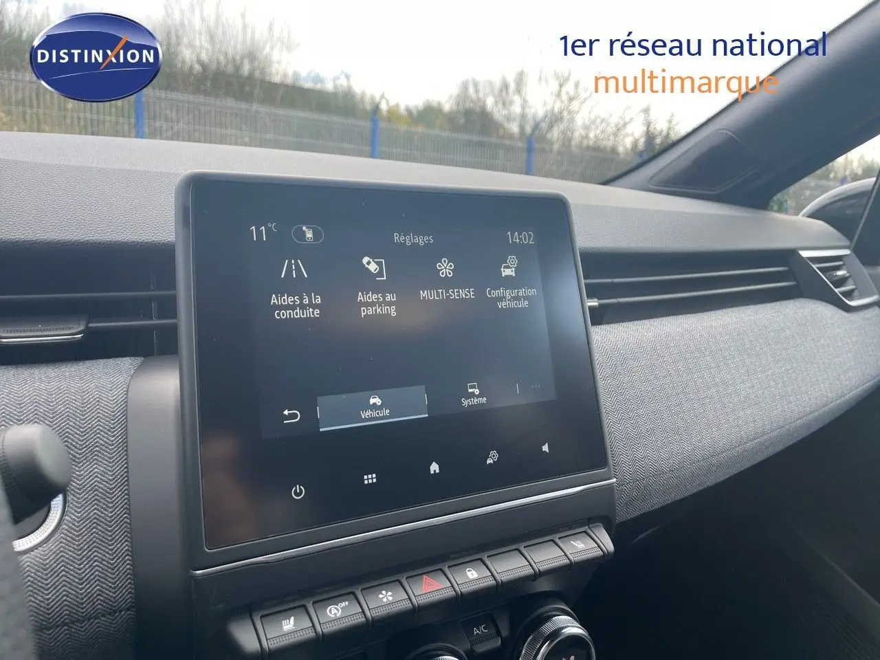 Vue intérieure du tableau de bord de la Renault Clio TCe 90ch Techno 2025 avec écran tactile et garniture tissu gris.