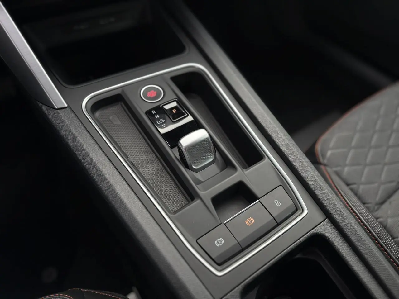 Gros plan sur la console centrale noire avec levier de boîte automatique de la SEAT LEON 1.5 e-TSI 150 DSG7 FR.