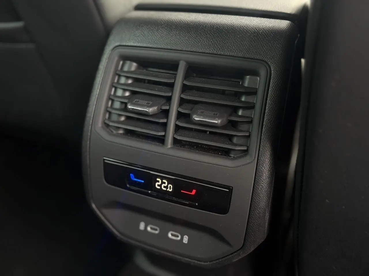 Gros plan sur la commande de climatisation arrière digitale et les prises USB-C du SEAT Leon blanc 2024.