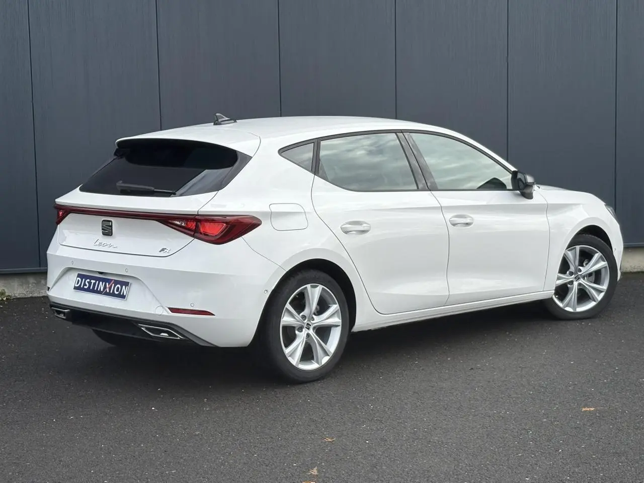 SEAT Leon 1.5 e-TSI 150 DSG7 FR blanc vue 3/4 arrière droit avec jantes alliage 17 pouces et feux LED arrière.