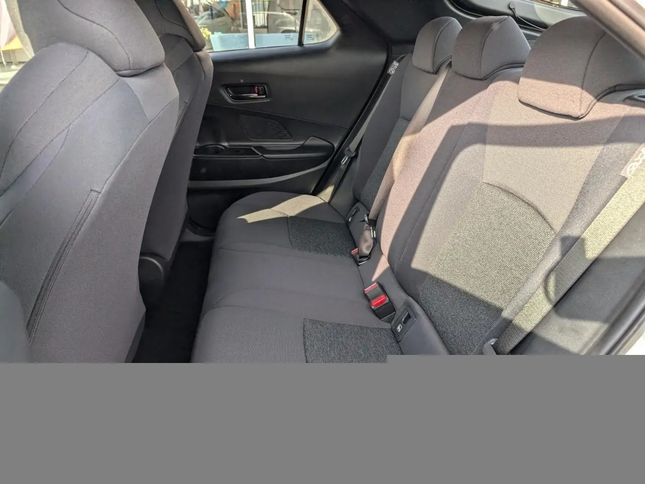 Vue intérieure côté droit des sièges arrière en tissu gris foncé du Toyota C-HR 1.8 Hybrid 2024.