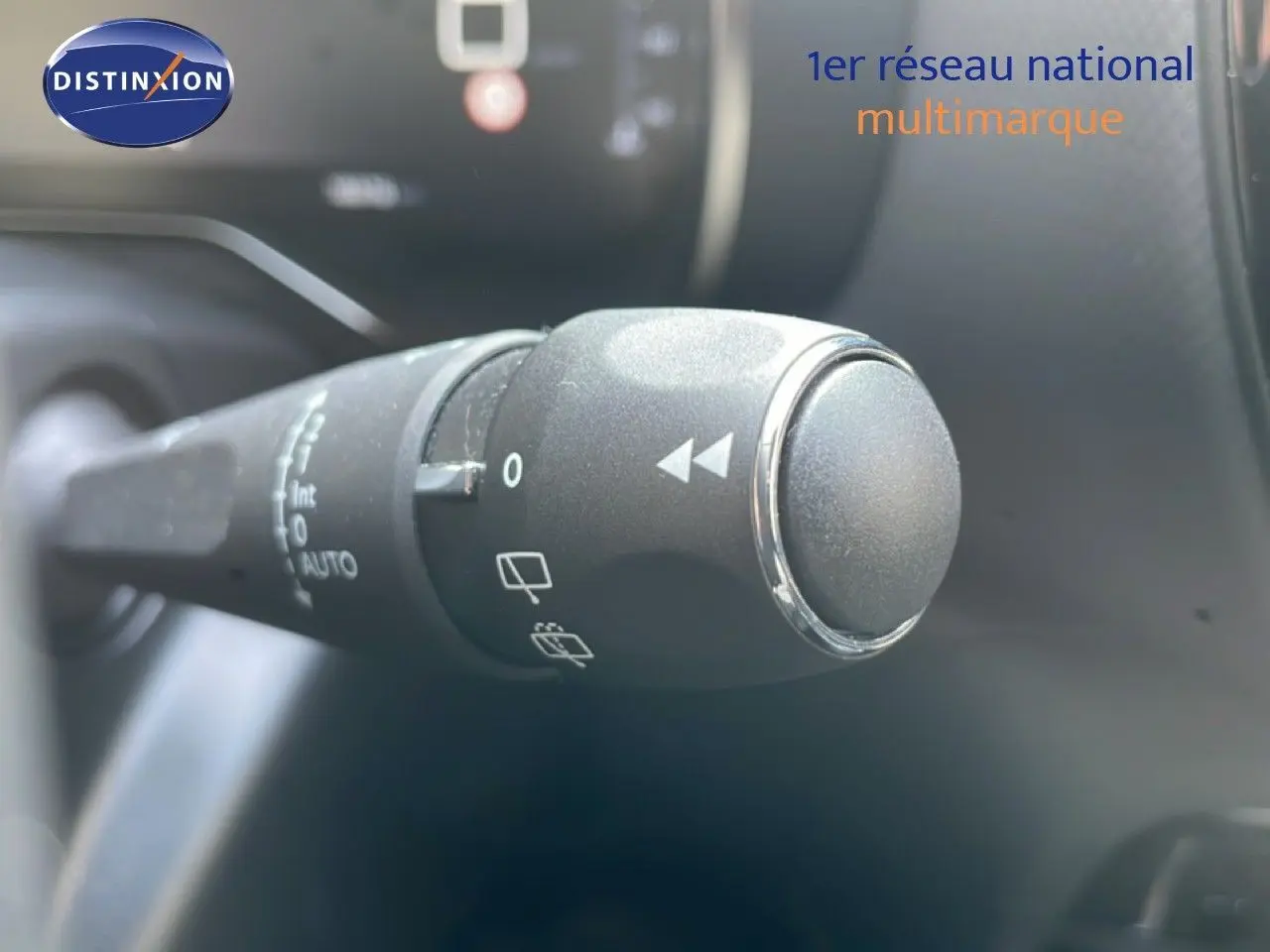 Gros plan sur la commande d'essuie-glace à gauche du volant dans l'habitacle du Citroën C5 Aircross bleu Eclipse Metal.