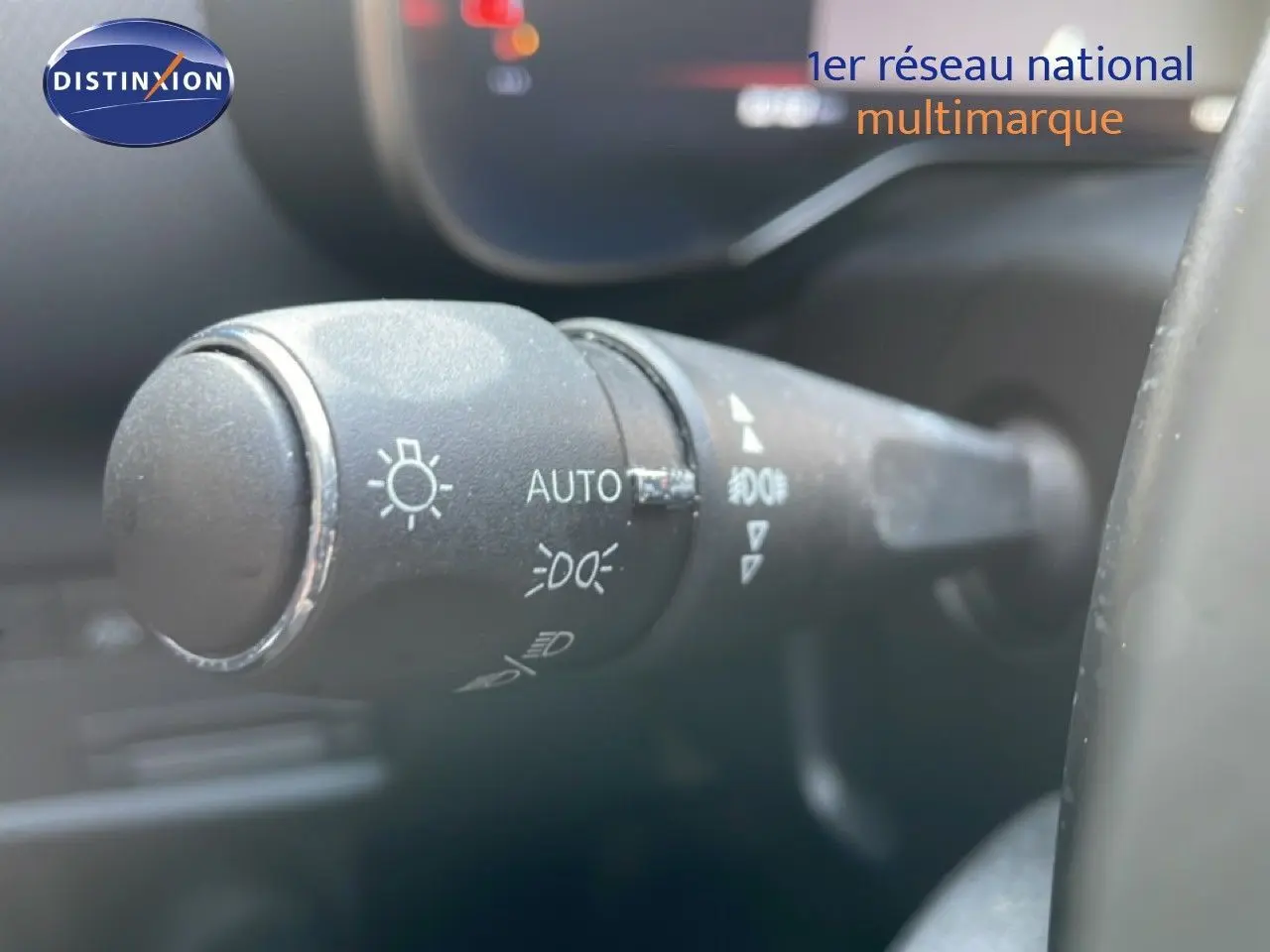 Gros plan sur la commande des phares du Citroën C5 Aircross 2025, intérieur gris noir avec volant partiellement visible.