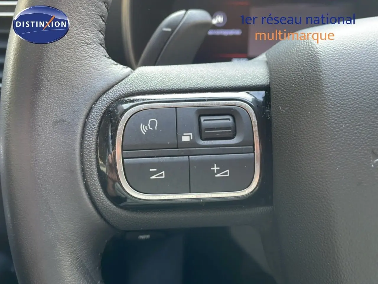 Gros plan sur les commandes de volume et de voix au volant du Citroën C5 Aircross 2025, intérieur noir.
