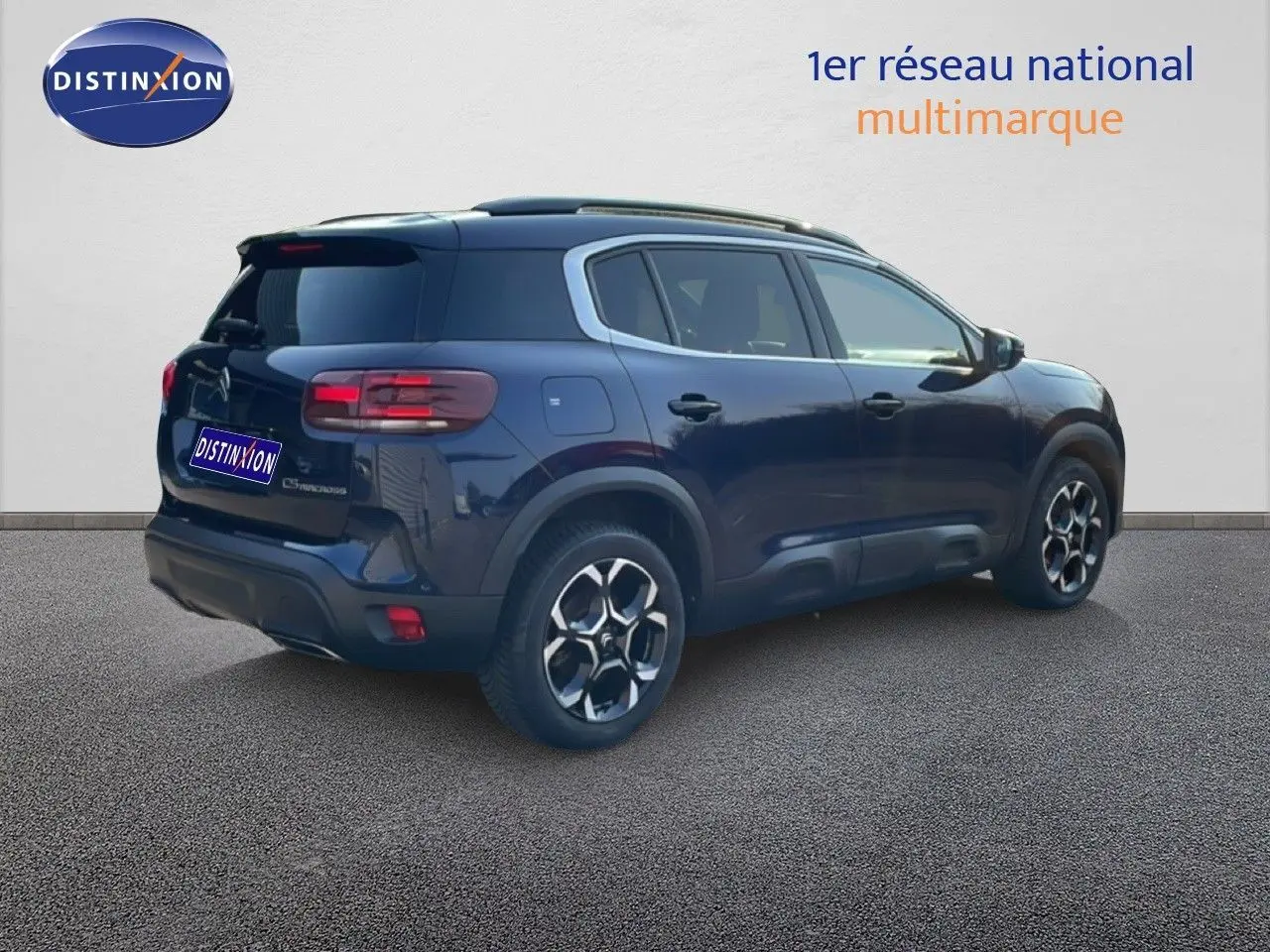 Vue 3/4 arrière droit d'un Citroën C5 Aircross bleu Eclipse Métal avec jantes bi-ton et toit noir.