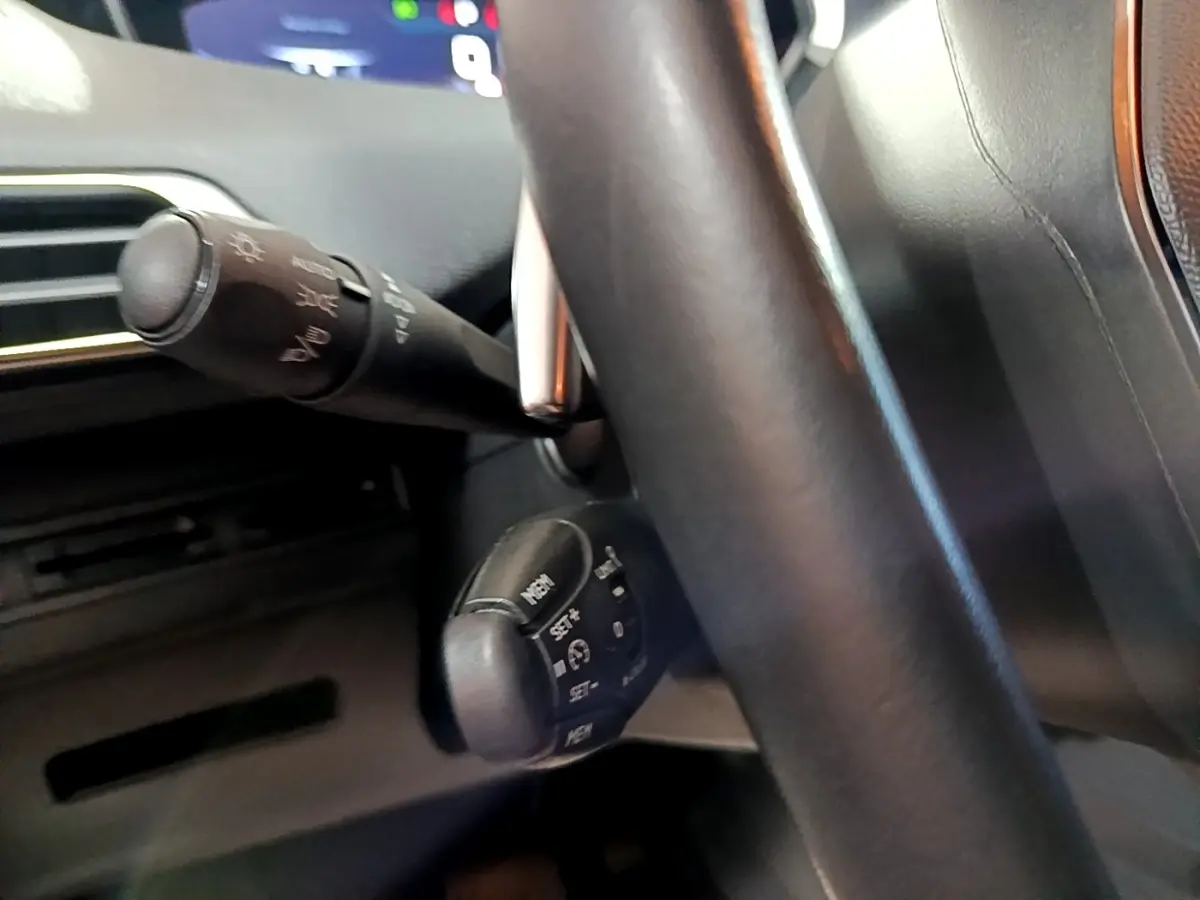 Gros plan sur la commande multifonction sous le volant cuir du Peugeot 5008 gris clair, version 2020.