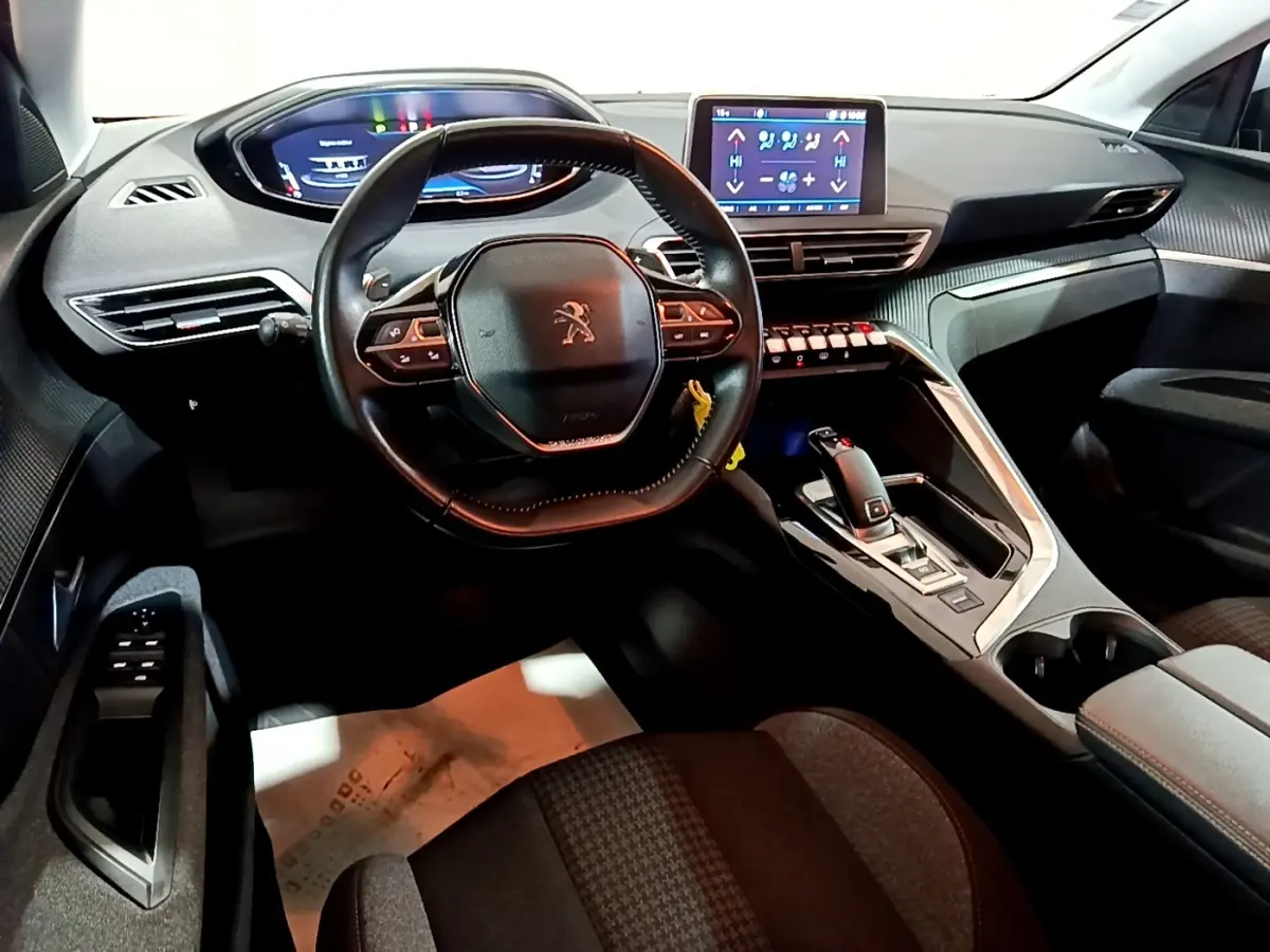 Vue intérieure avant du Peugeot 5008 2020, tableau de bord moderne avec écran tactile et volant cuir multifonctions.