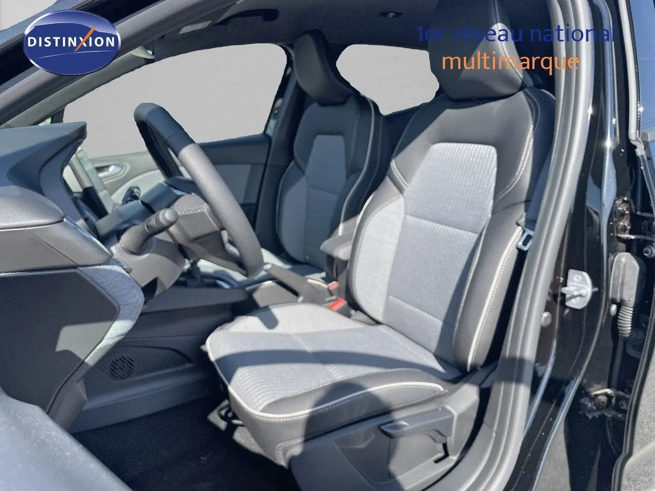 Vue intérieure côté conducteur de la Renault Clio TCE 90CH TECHNO 2025 avec sièges tissu gris et noir métal extérieur.