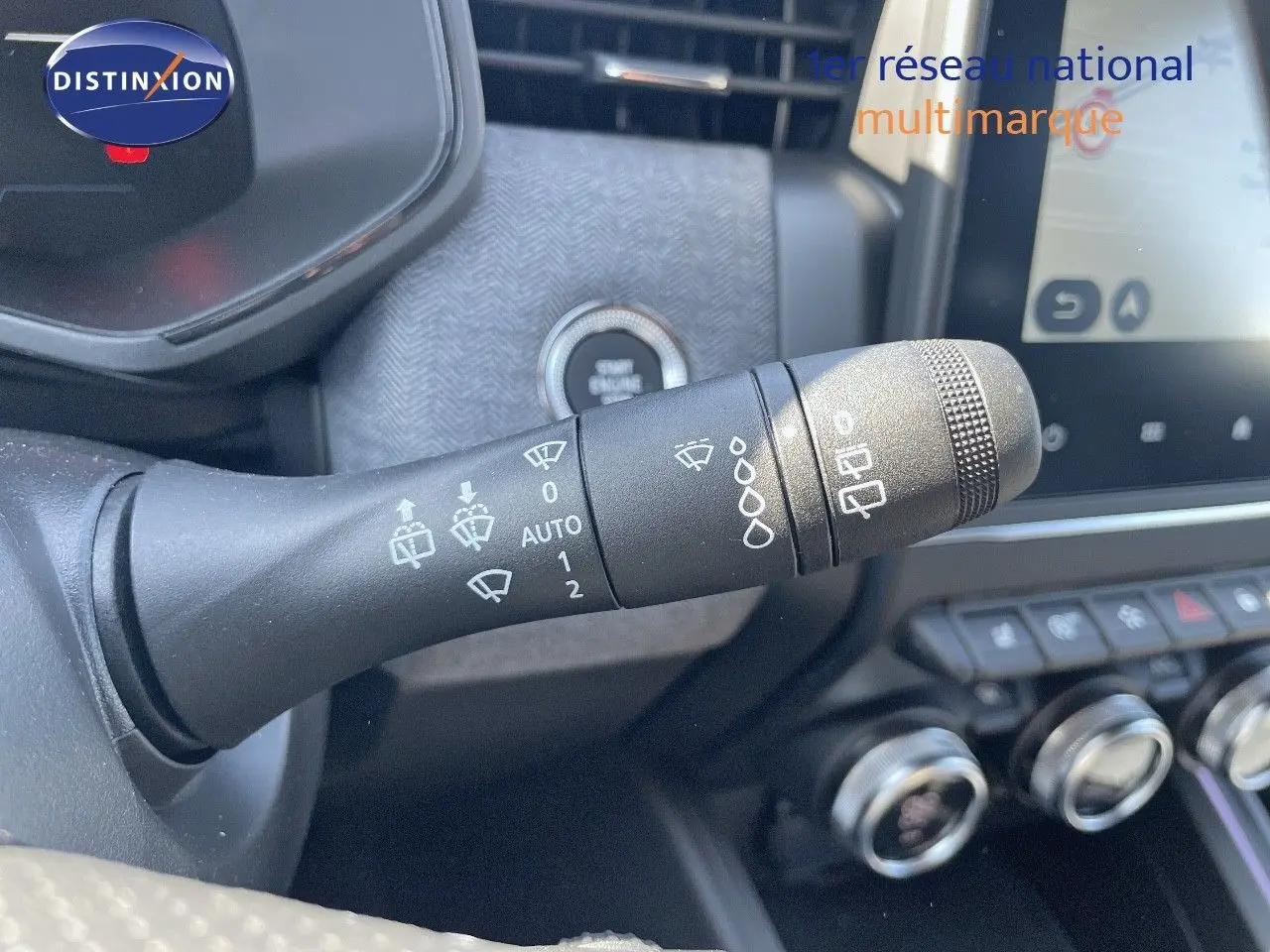Gros plan sur la commande d'essuie-glace de la Renault Clio TCE 90CH TECHNO 2025, intérieur noir avec tableau de bord moderne.