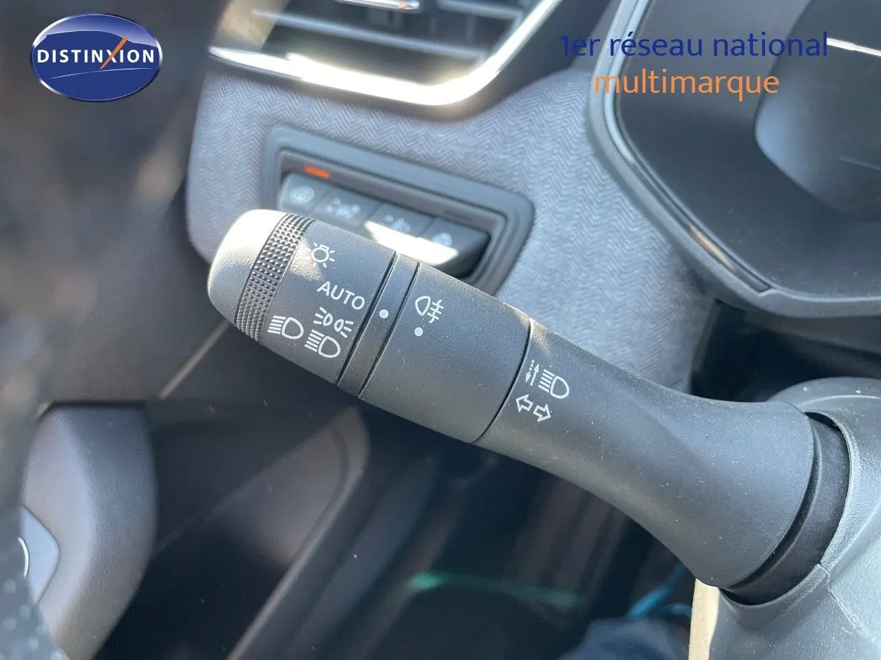 Gros plan sur la commande des phares et clignotants dans l'habitacle d'une Renault Clio noire 2025.