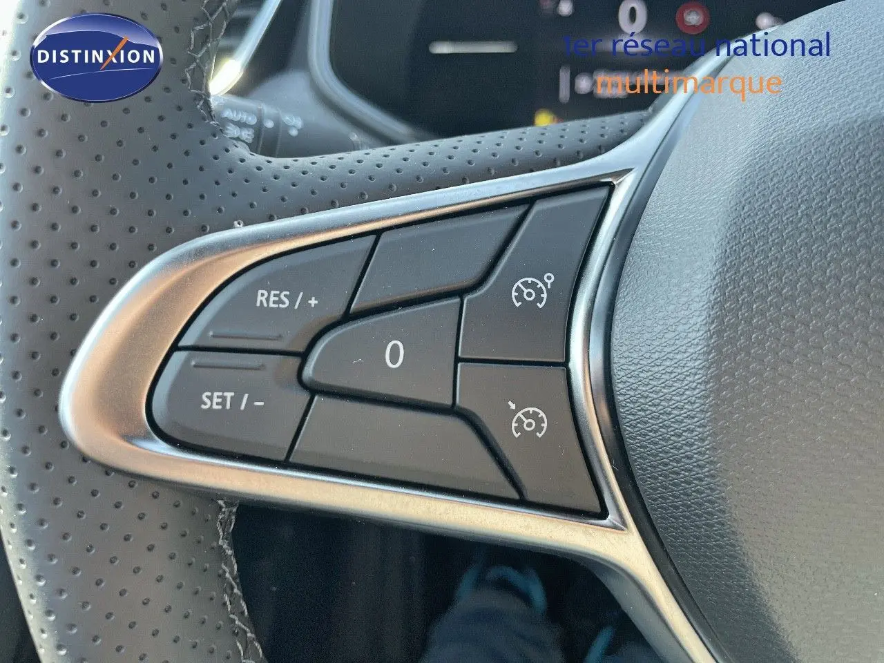Gros plan sur les commandes du régulateur de vitesse au volant perforé de la Renault Clio TCE 90CH TECHNO noir métal 2025.
