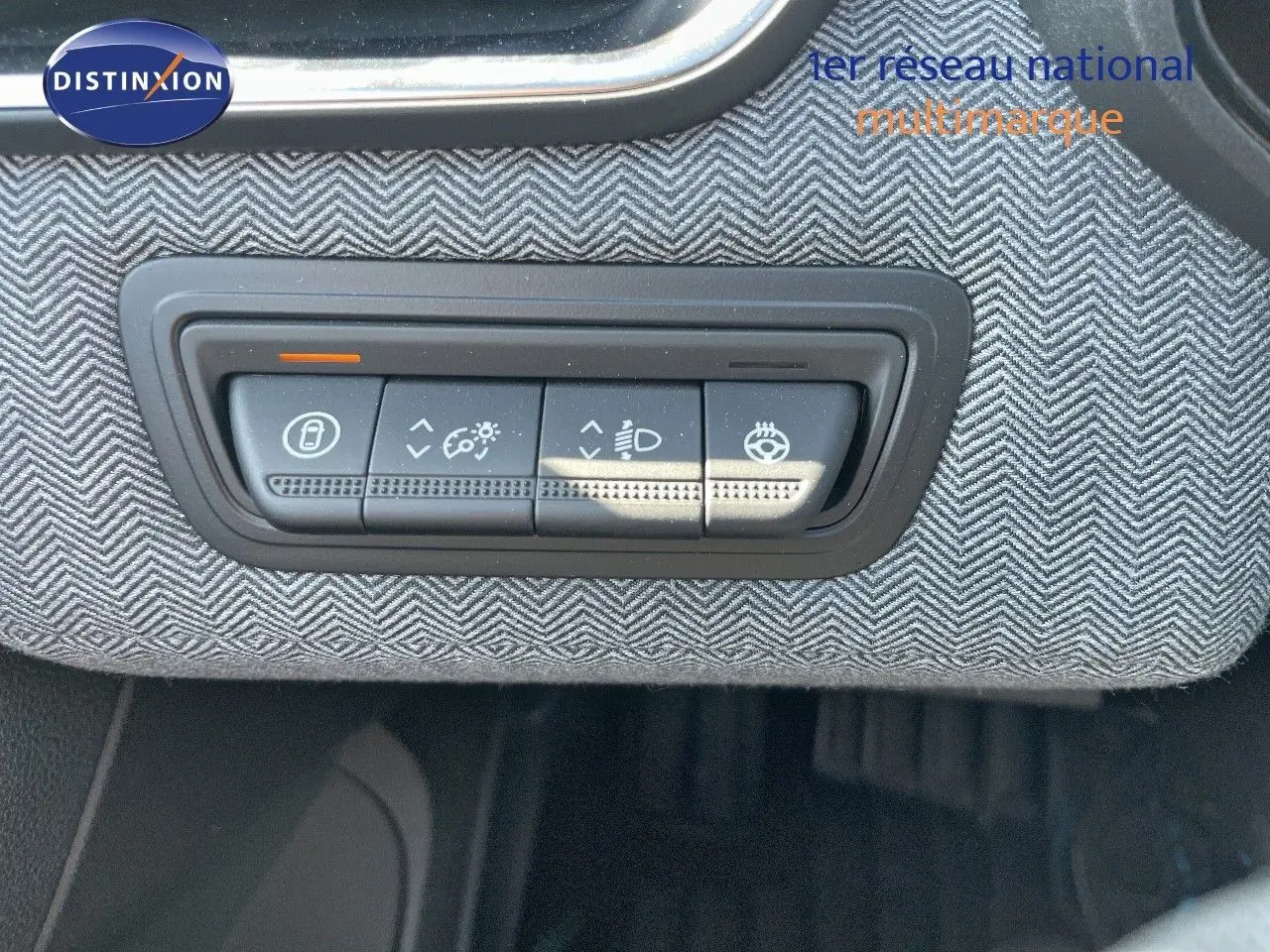 Gros plan sur les commandes d'éclairage intégrées dans le tableau de bord en tissu gris de la Renault Clio TCe 90ch Techno.