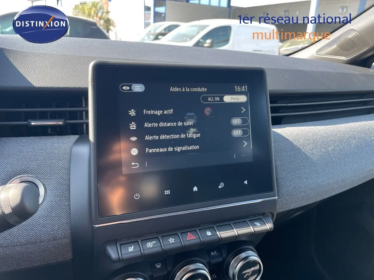 Vue rapprochée de l’écran tactile central du tableau de bord d’une Renault Clio noire métal 2025 affichant les aides à la conduite.