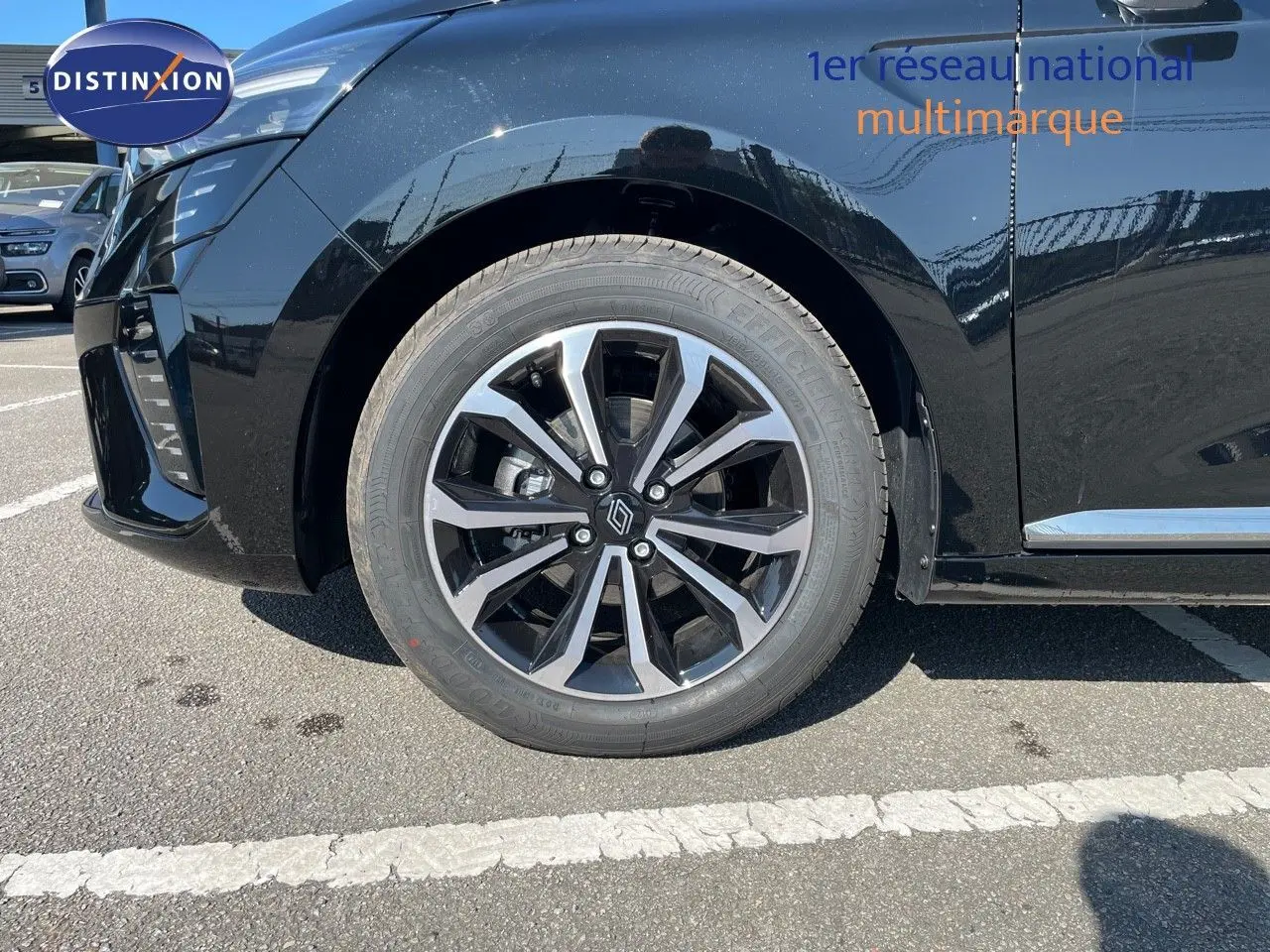 Gros plan sur la roue avant gauche de la Renault Clio TCE 90CH TECHNO noire métal avec jante alliage bicolore.