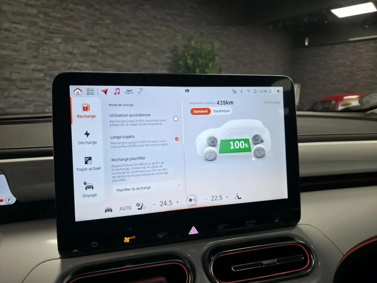 Écran tactile central du tableau de bord d'une Smart #1 blanche affichant l'état de charge à 100%