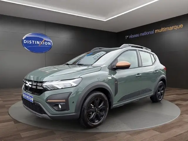 Vue 3/4 avant droite d'une Dacia Sandero Stepway 2025 kaki lichen avec rétroviseurs couleur cuivre et jantes noires.