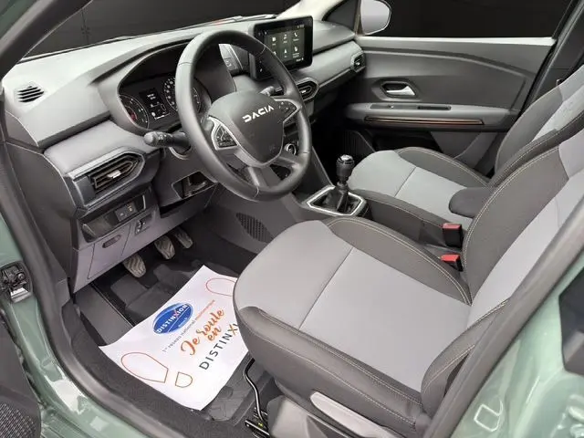 Vue intérieure côté conducteur de la Dacia Sandero Stepway 2025 kaki lichen, avec volant multifonction et boîte manuelle visible.