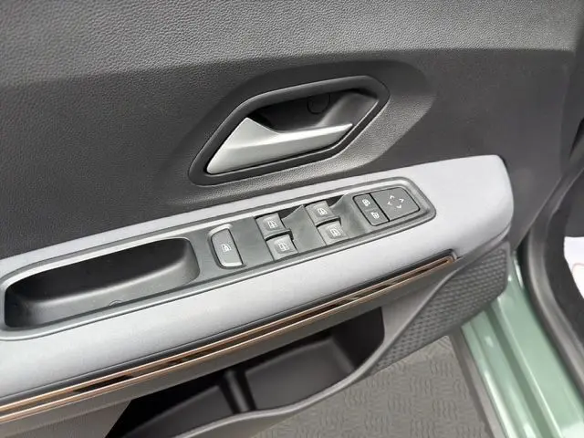 Détail de la porte côté conducteur de la Dacia Sandero Stepway 2025 kaki lichen, avec commandes des vitres et rétroviseurs.