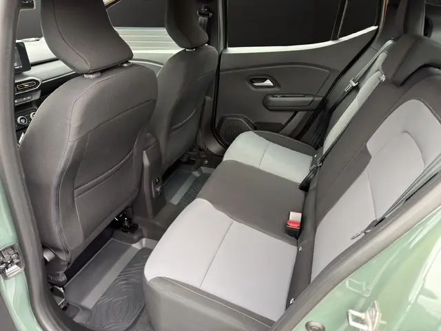 Vue intérieure arrière côté gauche du Dacia Sandero Stepway 2025 kaki lichen, montrant les sièges arrière bicolores et les portières.