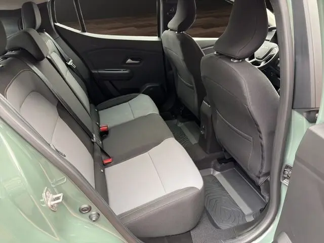 Vue intérieure arrière côté droit de la Dacia Sandero Stepway 2025 en kaki lichen, montrant les sièges bi-ton et les ceintures de sécurité.