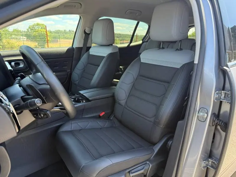 Vue intérieure côté conducteur du Citroën C5 Aircross gris acier, mettant en valeur les sièges bi-ton en tissu et cuir.