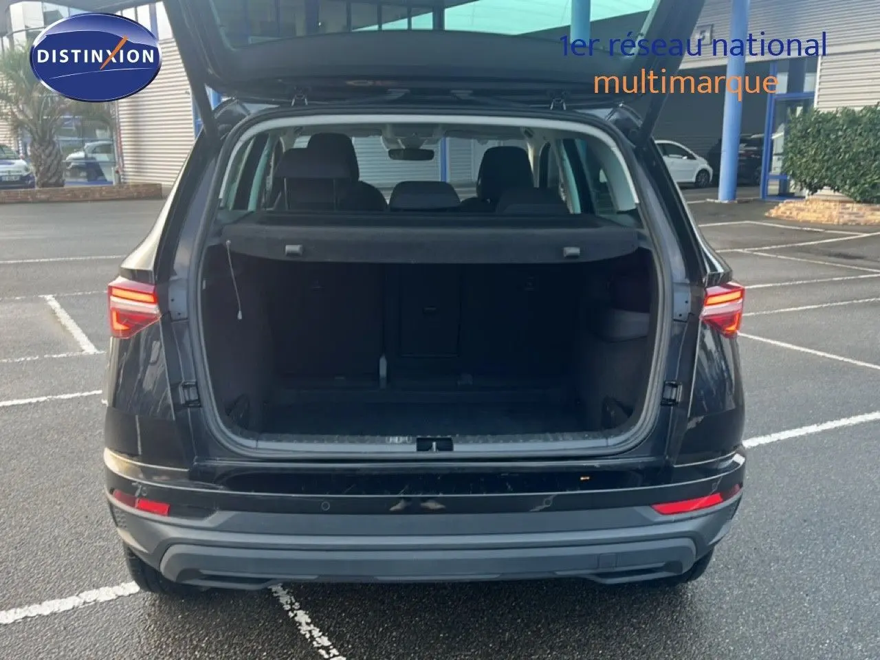 Vue arrière d'un Skoda Karoq noir Magic Metal avec coffre ouvert, mettant en valeur son espace de chargement.