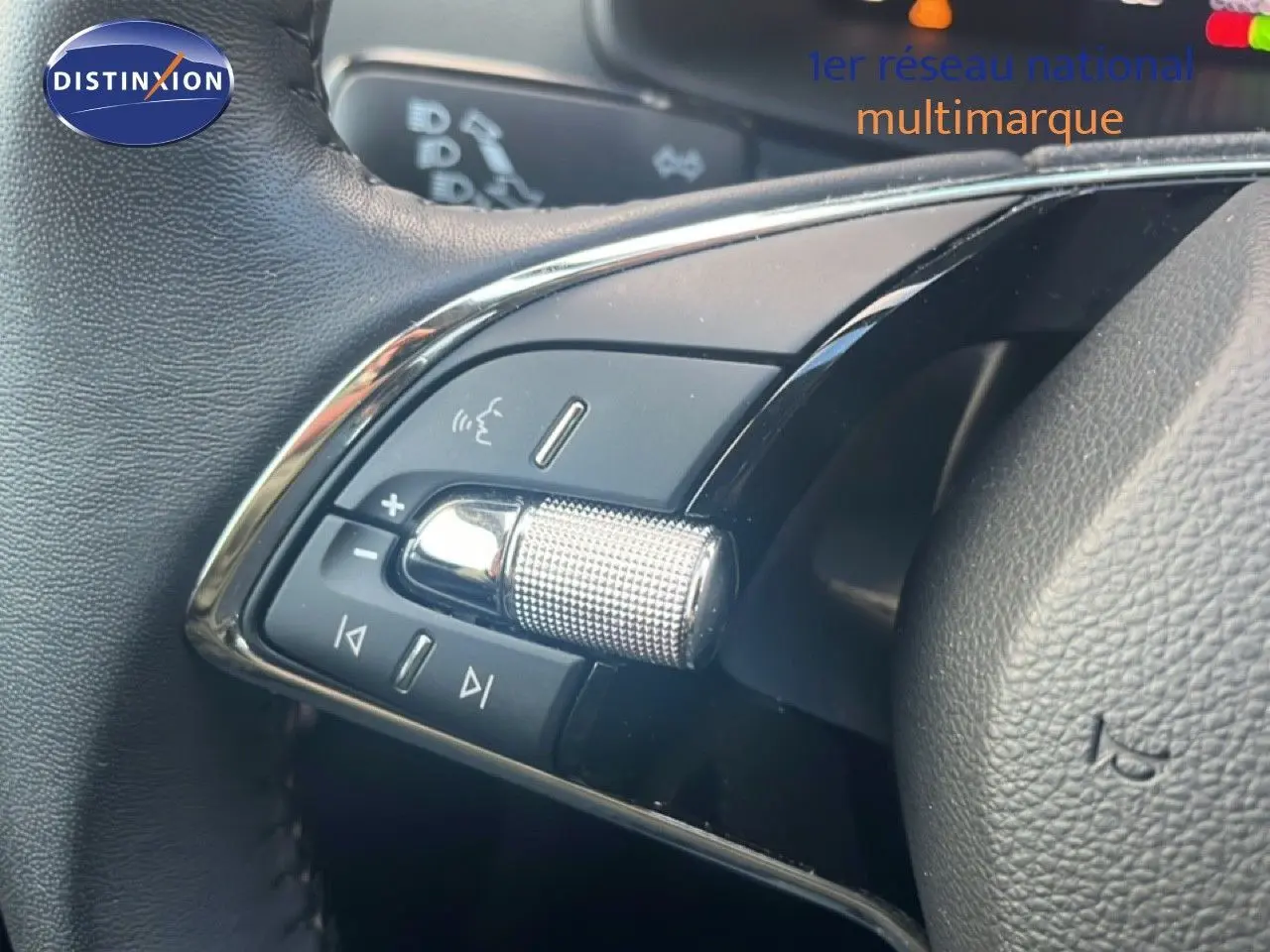 Gros plan sur les commandes audio au volant du Skoda Karoq 2023, finition Business, cuir noir et molette chromée.