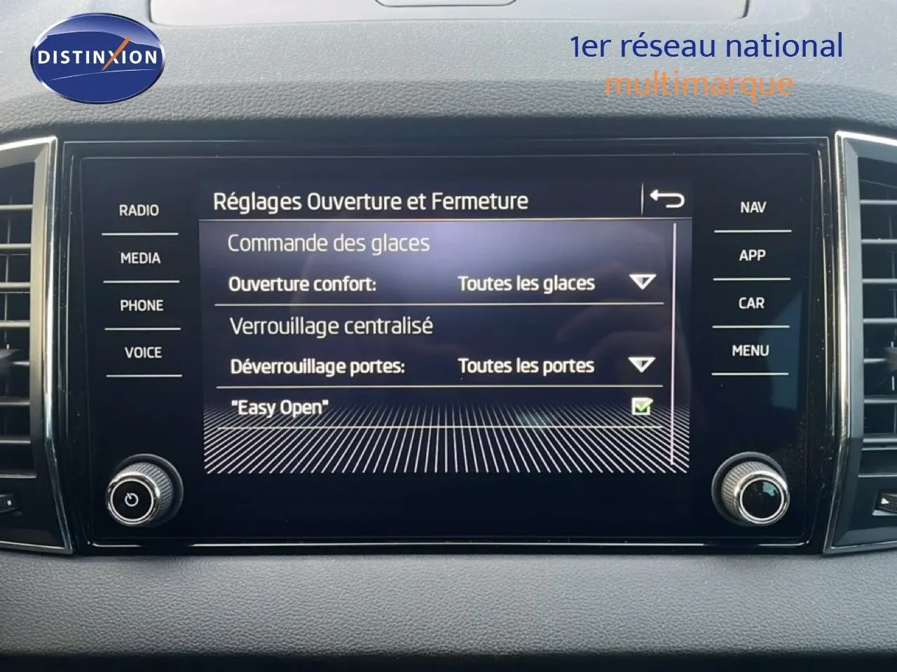 Écran tactile central du Skoda Karoq 2023 affichant les réglages d'ouverture et fermeture des vitres et portes.