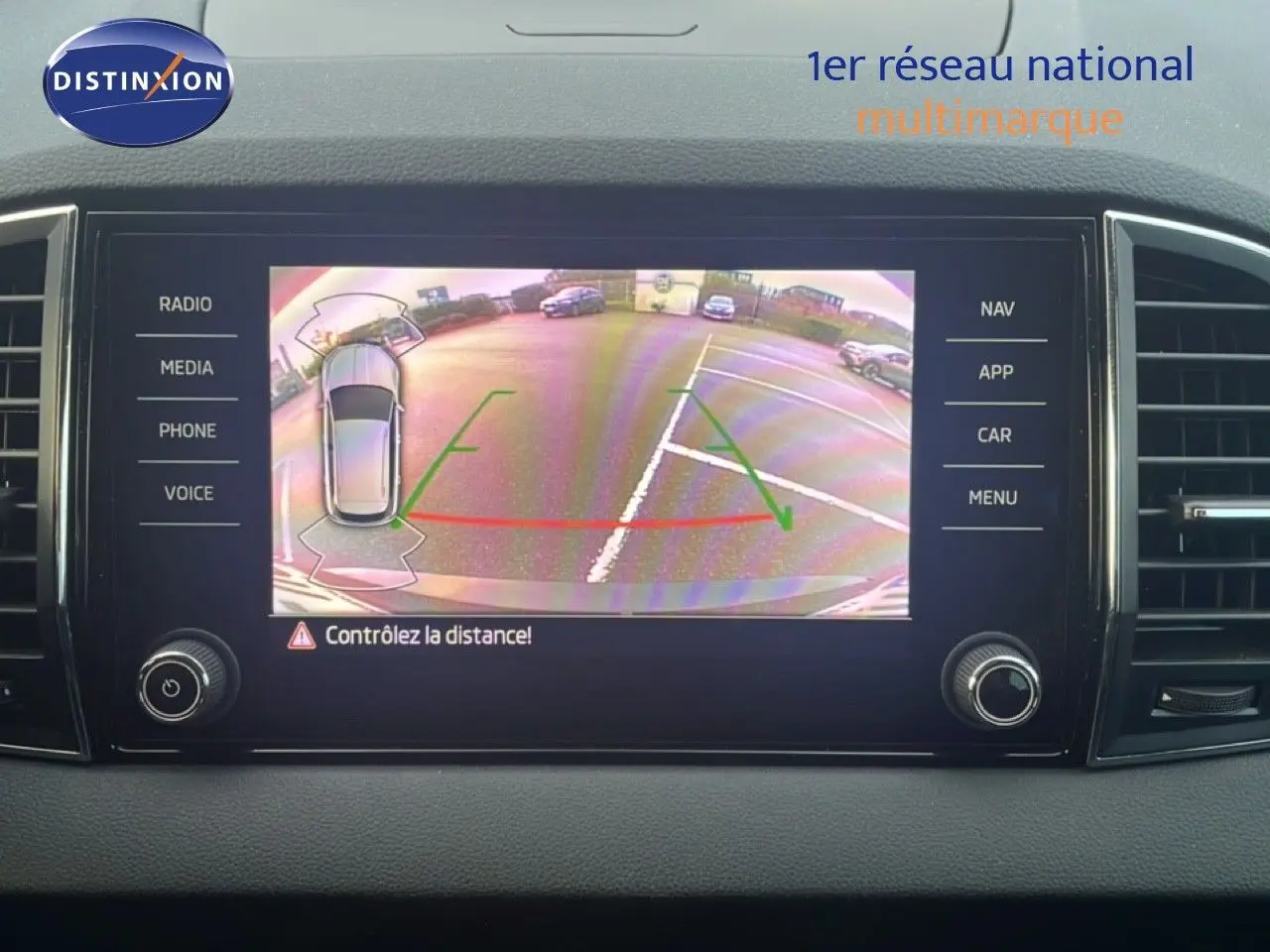 Écran multimédia montrant la caméra de recul d'une Skoda Karoq noir magic metal en stationnement arrière.