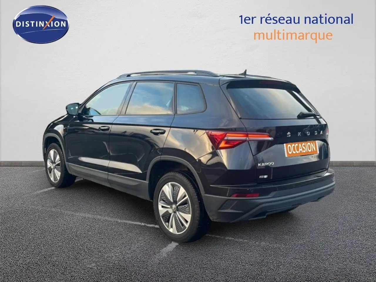 Vue 3/4 arrière droite d'un SKODA KAROQ noir Magic Metal avec jantes bi-ton et feux LED arrière allumés.