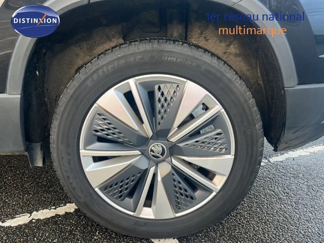 Gros plan sur la roue avant gauche d'un SKODA KAROQ noir Magic Metal avec jante alliage 17 pouces bicolore.