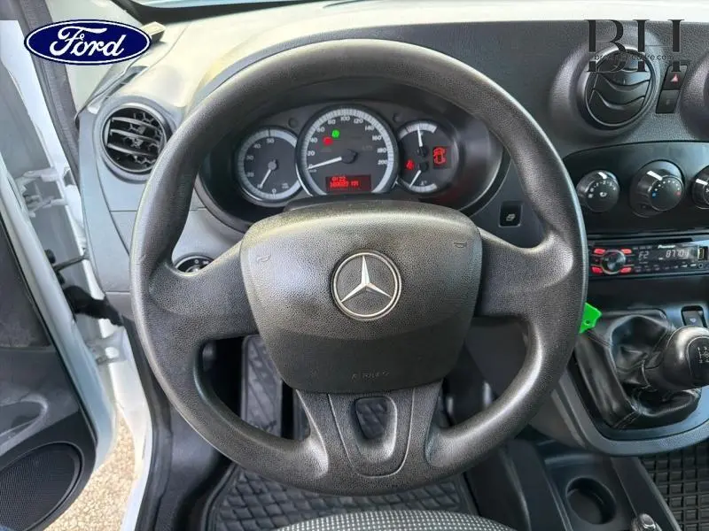 Vue intérieure côté conducteur du Mercedes Citan 108 CDI Compact blanc de 2017, volant, tableau de bord et levier de vitesse manuelle visibles.