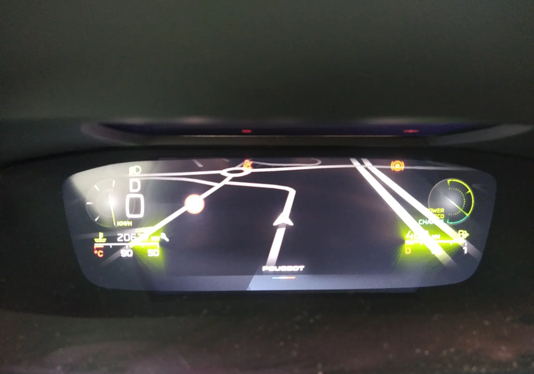 Affichage numérique du tableau de bord de la Peugeot 408 Hybrid 2024 montrant la navigation et les indicateurs de vitesse et énergie.