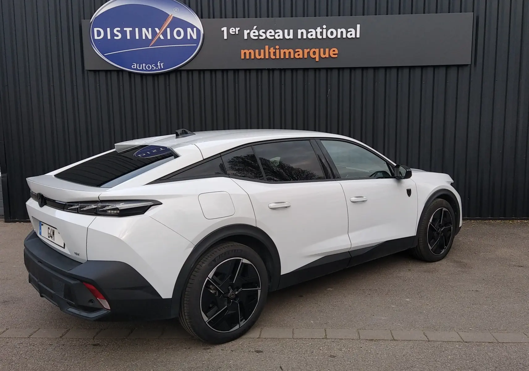 Peugeot 408 Hybrid blanc Okenite vue 3/4 arrière côté droit, avec jantes noires et vitres teintées.