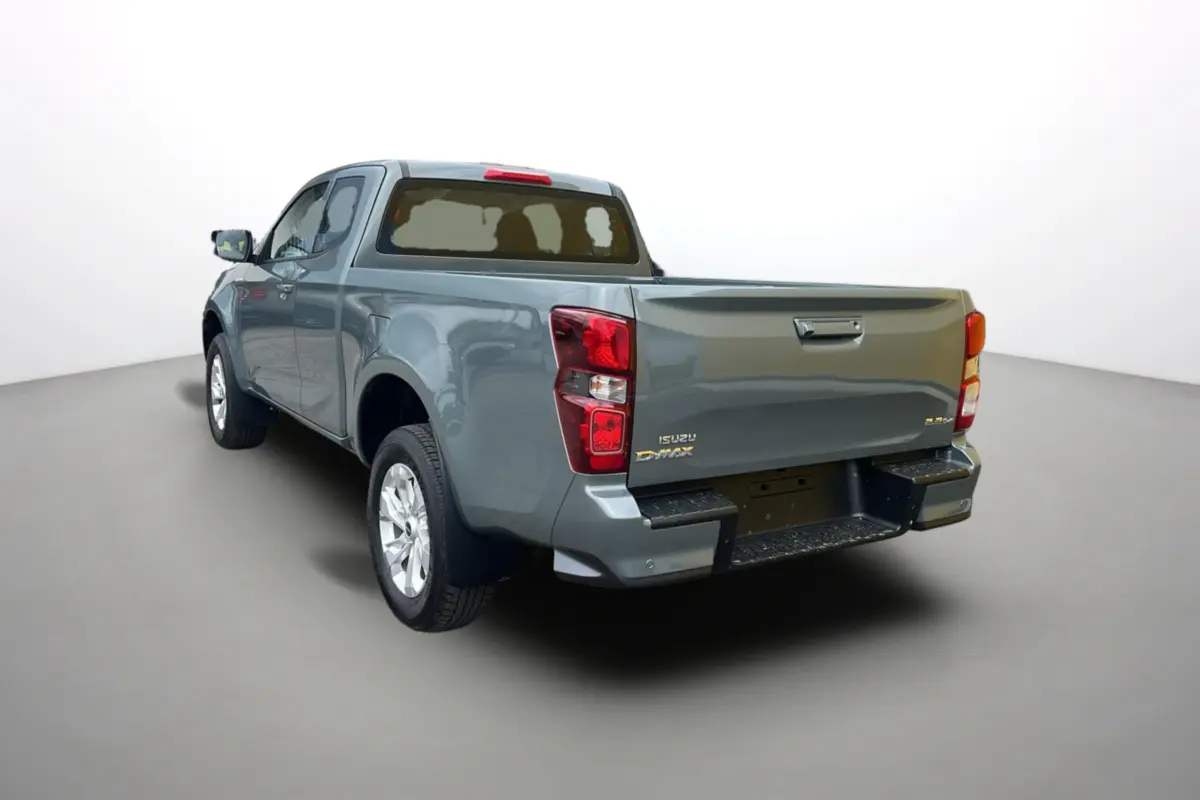 Vue 3/4 arrière gauche d'un Isuzu D-MAX 2026 vert Inishmore métallisé avec benne et jantes alu.