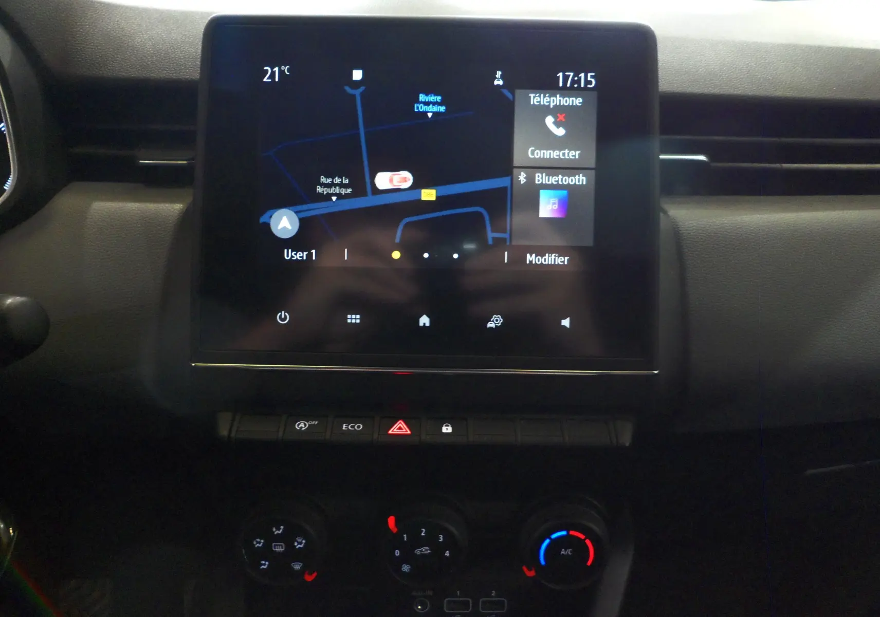 Écran tactile central avec navigation et commandes climatisation dans l'habitacle d'une Renault Clio V blanche.