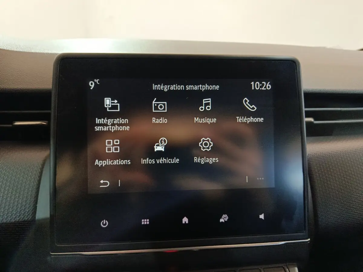 Écran tactile central de la Renault Clio gris clair 2023 affichant les options smartphone, radio, musique et téléphone.