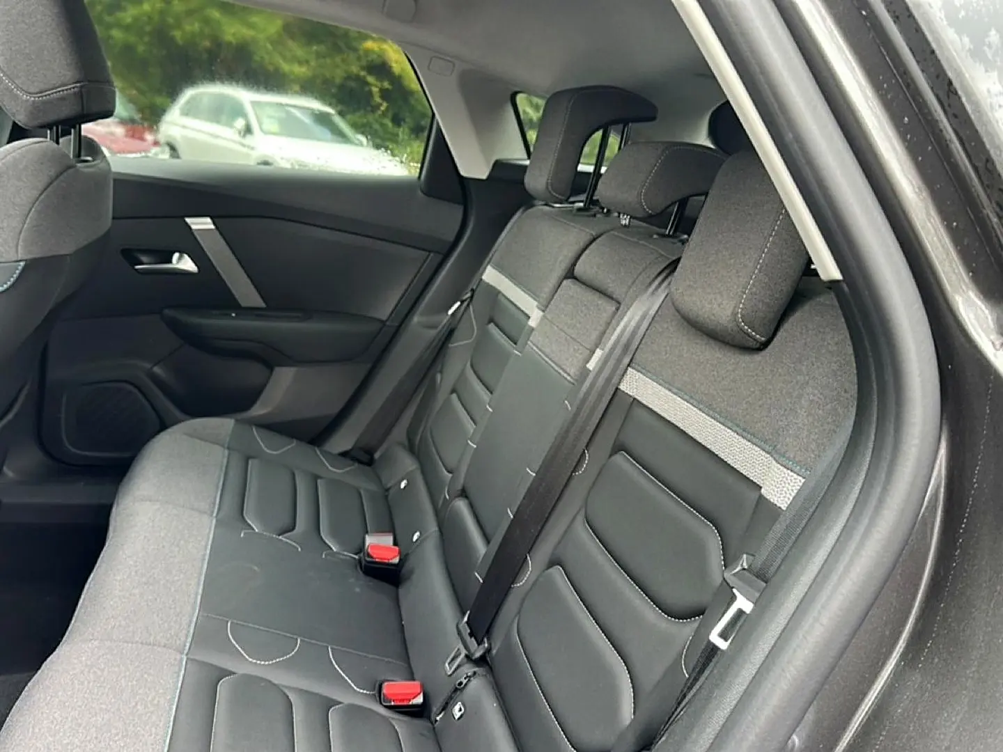 Vue intérieure côté droit sur la banquette arrière gris foncé et tissu noir du Citroën C4 2024.