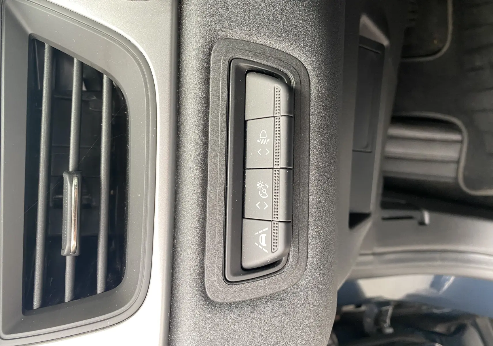 Gros plan sur les boutons de réglage d'assistance et l'aération intérieure du Mitsubishi ASX 2023 gris Steel Gray.