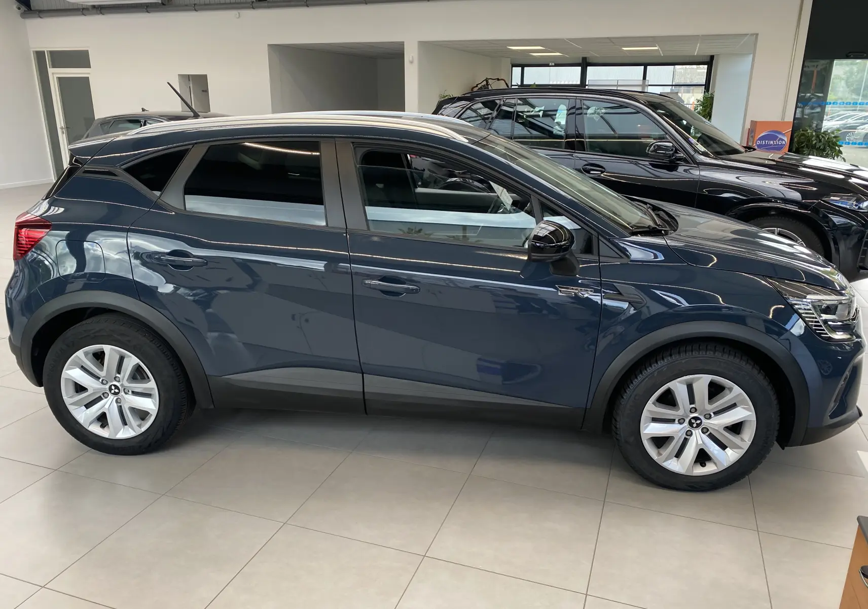 Vue de profil côté gauche du Mitsubishi ASX 2023 hybride en Steel Gray métallisé, avec jantes alliage et vitres teintées.