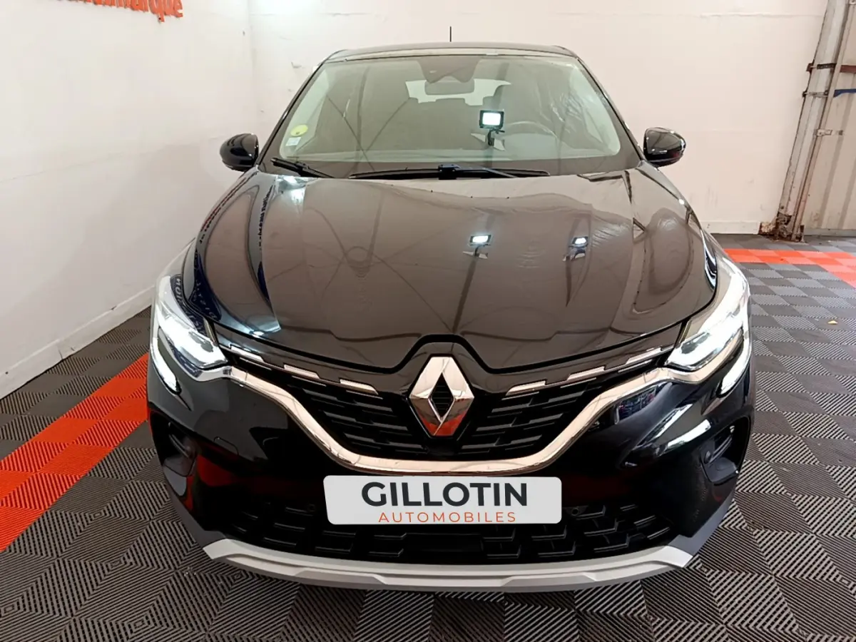 Vue frontale d'un Renault Captur noir 2020 avec calandre chromée et phares LED allumés en intérieur showroom.