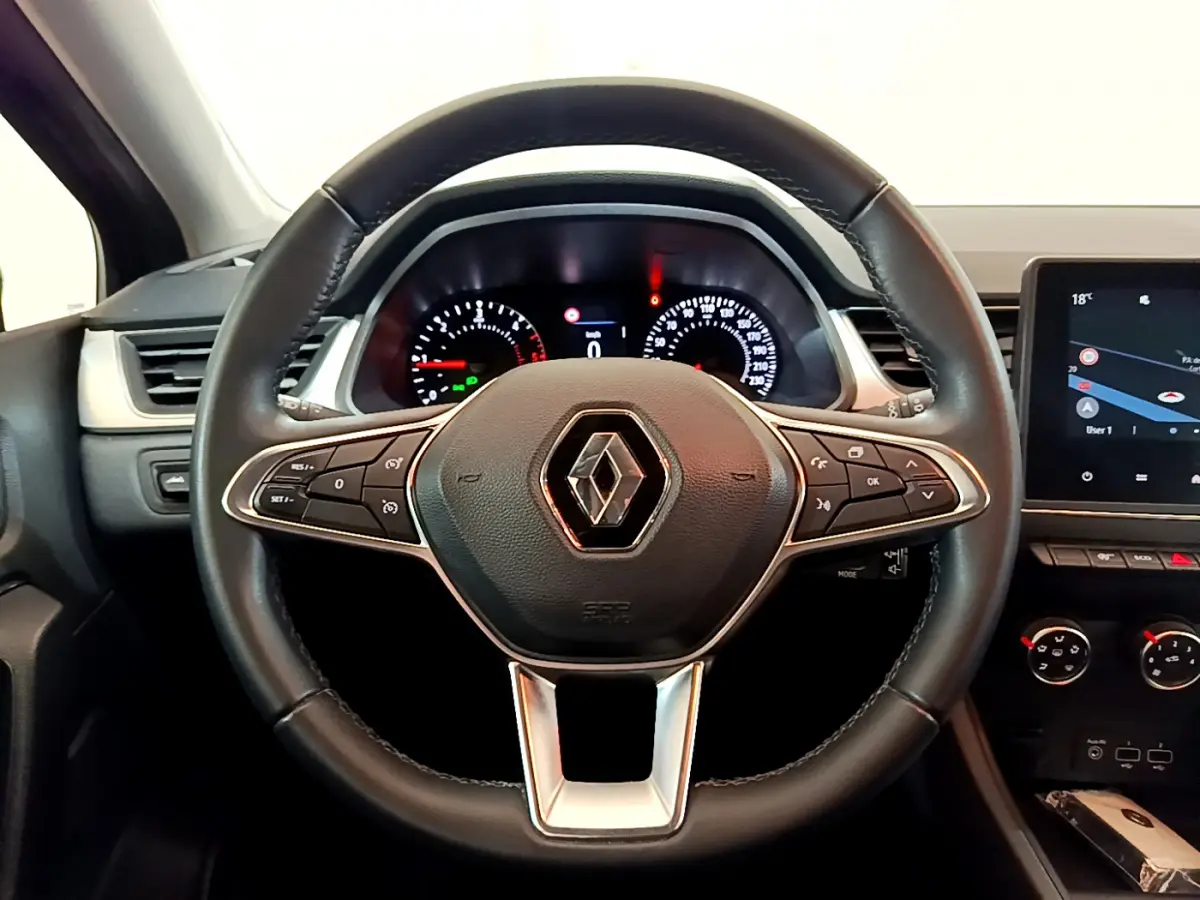 Vue rapprochée du volant noir de la Renault Captur 2020 avec tableau de bord et écran tactile à droite.