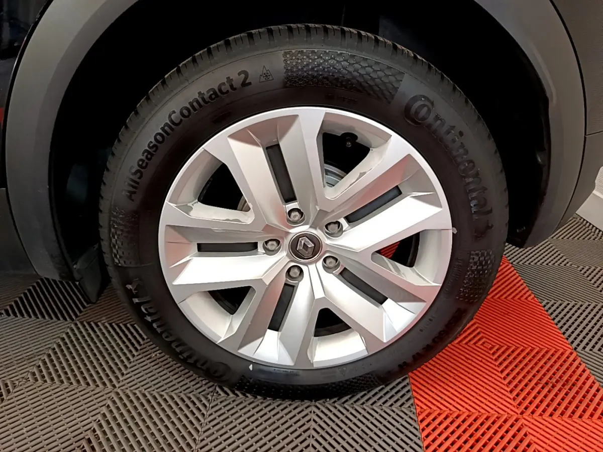 Gros plan sur la roue avant droite du Renault Captur Business noir, mettant en valeur la jante argentée et le pneu Continental.