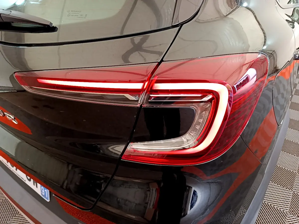 Gros plan sur le feu arrière droit rouge du Renault Captur Business noir, soulignant la finition moderne du modèle 2020.