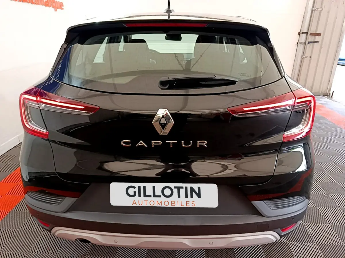 Vue arrière d'un Renault Captur Business noir avec feux LED allumés dans un garage lumineux.